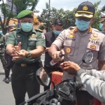 Kapolresta Sidoarjo, Kombes Pol Sumardji saat menyemprotkan hand sanitizer ke pengendara bermotor.