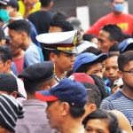 Seorang polisi sedang berada di tengah-tengah massa pendukung salah satu calon Bupati Bojonegoro. 