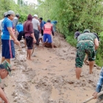Masyarakat dibantu anggota TNI saat menyingkirkan lumpur tanah longsor.