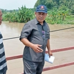 Wakil Ketua DPRD Nur Qolib ketika memantau luapan kali lamong yang merendam jalan desa.