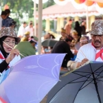 SERIUS: Tim Dinas Kominfo saat mengikuti lomba melukis payung di Alun-alun Sidoarjo, Rabu (30/8). foto: Kominfo 