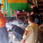 Petugas saat mengevakuasi driver Ojol yang tewas mendadak di Surabaya.