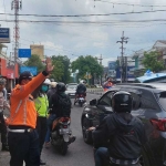 Petugas saat mengevakuasi taksi yang terguling usai tabrak trotoar di Sidoarjo. 