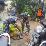 Personel gabungan yang terdiri dari TNI- Polri, BPBD, dan FRPB Pamekasan gotong royong membersihkan lumpur sisa banjir.
