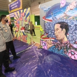 Wakapolda Jawa Timur, Brigjen Pol Slamet Hadi Supraptoyo, sedang memandangi karya mural bergambar Presiden Jokowi yang menjadi juara I.