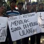 PROTES: Warga Desa Ketegan Kecamatan Tanggulangin membeber poster saat demo terkait Pilkades di depan gedung DPRD Sidoarjo, Senin (11/7). foto: MUSTAIN/ BANGSAONLINE