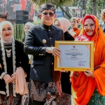 Pj Gubernur Jatim, Adhy Karyono (kiri), saat memberikan penghargaan kepada Plt Bupati Gresik, Aminatun Habibah, dalam upacara peringatan Hari Jadi ke-79 Provinsi Jawa Timur. Foto: Ist