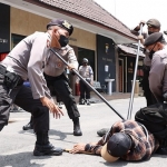 Sejumlah personel Polres Jombang saat melumpuhkan pria bersajam dengan menggunakan alat Sasumata.
