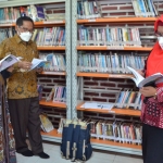 Wabup Bu Min (kanan) saat membaca buku di Perpustakaan Mesin Waktu Desa Sukoanyar, Kecamatan Cerme. (foto: SYUHUD/ BANGSAONLINE)