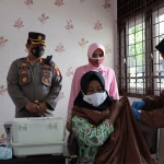 Kapolres Gresik, AKBP Mochamad Nur Azis, bersama istrinya ketika memantau vaksinasi booster di SLB Kemala Bhayangkari. Foto: SYUHUD/ BANGSAONLINE