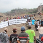 Warga Desa Bulusari membentangkan spanduk berisi dukungan atas program pembangunan perumahan prajurit.