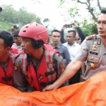 Kapolres Madiun, AKBP I Made Agus Prasetya membantu mengangkat jenazah korban tenggelam di sungai di Wana Wisata Grape, Kecamatan Wungu, Kabupaten Madiun. foto: kompas.com