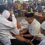 Tukang calak saat melakukan proses khitan terhadap salah satu peserta.