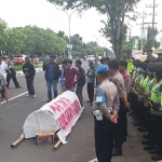 Mathur Koorlap aksi dalam orasinya di depan Kantor Kejaksaan Negeri Bangkalan. foto: FAUZI/ BANGSAONLINE