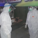 Petugas yang hendak mengevakuasi korban tampak mengenakan pakaian hazmat.