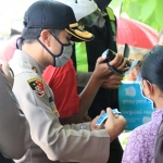 Kapolres Pasuruan AKBP Rofiq ripto Himawan saat memberikan bantuan pada warga miskin yang tidak masuk dalam DTKS.