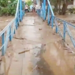 Banjir merendam salah satu jembatan penghubung desa hingga tak terlihat. 