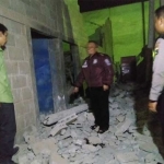 Petugas menunjukkan reruntuhan dinding pabrik yang ambrol akibat angin puting beliung.