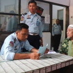 Slamet Rudhu, seorang narapidana kasus terorisme saat mengurus berkas bersama petugas dari Lapas Surabaya.