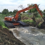 Alat beras jenis eskavator saat melakukan pengerukan Sungai Wrati di Kecamatan Beji.