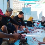 Tim Lumbung Kebaikan Kediri dibantu warga saat memotong daging kurban. Foto: Ist
