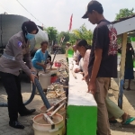Anggota Polres Jombang saat bagikan air bersih di Desa Manduro.