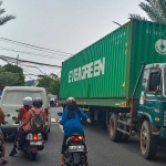 Truk tronton berhenti di tengah jalan usai nyangkut kabel seluler yang menggelantung di perempatan Jalan Giri, Kebomas, Gresik. Foto: SYUHUD/ BANGSAONLINE