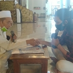 Imam Masjid Nasional Al-Akbar KH Abdul Hamid Abdullah menjabat tangan Bryan Febriyanto saat menuntun ikrar baca dua kalimat syahadat di  Masjid Nasional Al-Akbar, Surabaya, Jumat (10/7/2020). foto: MMA/ bangsaonline.com
