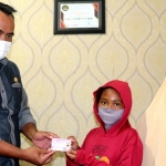 Syamsul Bahri, Kepala Dispendukcapil Kota Kediri saat menyerahkan KIA kepada salah satu anak. (Foto: Ist.)