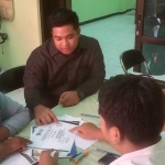 M. Syahrul Munir (baju hitam) saat mendampingi salah satu orang tua murid yang sertifikatnya ditolak saat hendak mendaftarkan sang anak pada PPDB jalur prestasi. Foto: SYUHUD/ BANGSAONLINE