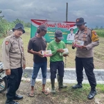 Petugas dari Polsek Balongbendo saat menyerahkan pupuk.