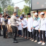 Kapolres Kediri Kota AKBP Bramastyo Priaji saat menyerahkan santunan kepada anak yatim. Foto: Ist.