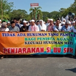 Ratusan massa GUIP membeber spanduk kecaman untuk Sukmawati saat menggelar aksi di kantor DPRD Kabupaten Pamekasan.