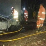 Kondisi mobil sedan yang terbakar. Petugas Damkar Jember saat masih di TKP.