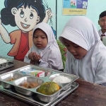 Siswa di SDN Pandian 1 saat menerima menu Makan Bergizi Gratis (MBG) di kelasnya. Foto: Kompas