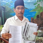 H. Ismar mantan Kepala Deas Batobella saat menunjukkan bukti ijazah Paket A, B, dan C milik Moh. Hasan yang diduga palsu, serta bukti laporan ke Polres Bangkalan pada Rabu, 31 Maret 2021.