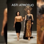 Fashion Designer Asti Atmodjo (kiri) saat menggandeng Putri Indonesia asal Jawa Timur sekaligus Putri Indonesia Pariwisata 2022 Adinda Cresheilla untuk memperagakan karyanya.