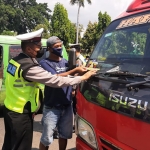 Petugas kepolisian saat menempelkan penanda bagi pelanggar lalu lintas di Kabupaten Tuban.
