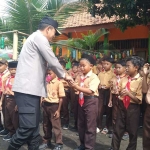 Kapolres AKBP Wisnu Wardana saat membagikan makan bergizi ke siswa SDN Jabung Candi. Foto: Andi Sirajudin.