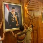 DITURUNKAN. Petugas di Grahadi menurunkan foto mantan presiden SBY. foto : nisa/bangsaonline