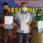 Ketua PD Gresik Eddy Santoso diapit Gus Yani dan Ning Min menunjukkan surat usulan paslon ke DPP, beberapa waktu lalu. foto: SYUHUD/ BANGSAONLINE