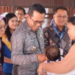 Wali Kota Batu saat menyapa seorang bayi bersama ibunya di Posyandu balita.