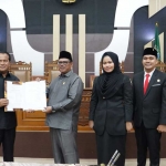 Pimpinan DPRD dan Pj Bupati Pasuruan Nurkholis menunjukkan dokumen Perda APBD tahun 2025.