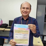 Unit Kredit Consumer BNI KC Kediri, Andi Setiyono, saat menunjukkan pengumuman layanan terbatas. Foto: Muji Harjita/Bangsaonline.