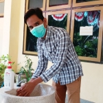 Mohammad Hotib, Ketua Fraksi PKB DPRD Bangkalan saat melakukan cuci tangan sebelum masuk ke kantor, Rabu (15/4).