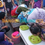 Para peserta lomba adu cepat memakan baby crab yang sudah diolah. Foto: SYUHUD/BANGSAONLINE