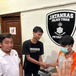 Rohmad (kaos hitam) saat didamaikan dengan pelaku yang menemukan ponsel miliknya di Mapolres Tuban. Foto: Suwandi/BANGSAONLINE