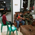 BS menggendong anaknya saat berada di Kantor Satpol PP Kota Kediri dan istrinya ENM yang digerebek karena selingkuh. foto: ist/ bangsaonline.com
