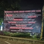 Spanduk terpampang di Jalan Dr Wahidin SH, Desa Randuagung, Kecamatan Kehomas berisikan ultimatum kepada Bupati Gresik. FOTO: ist.