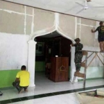 Warga dan anggota TNI berbaur membersihkan tempat ibadah. 